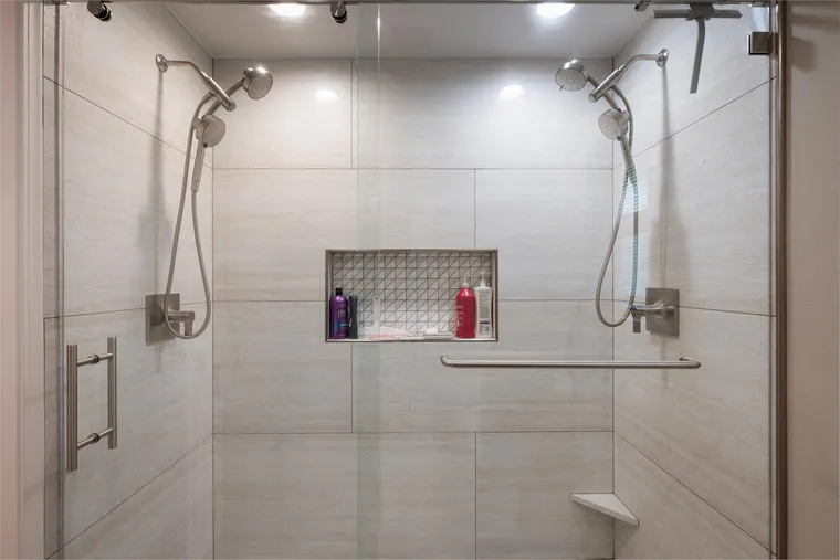 Double shower with two shower heads and a tiled niche