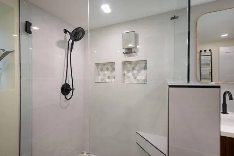 Glass shower with a hex tile niche and black fixtures