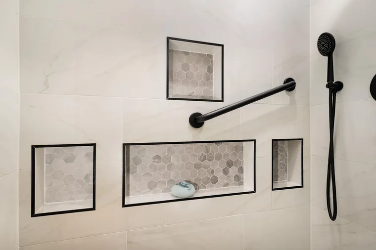 Black-framed shower niches lined with hex tile