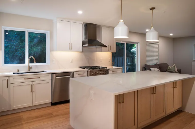 White kitchen with a waterfall peninsula on a wood base