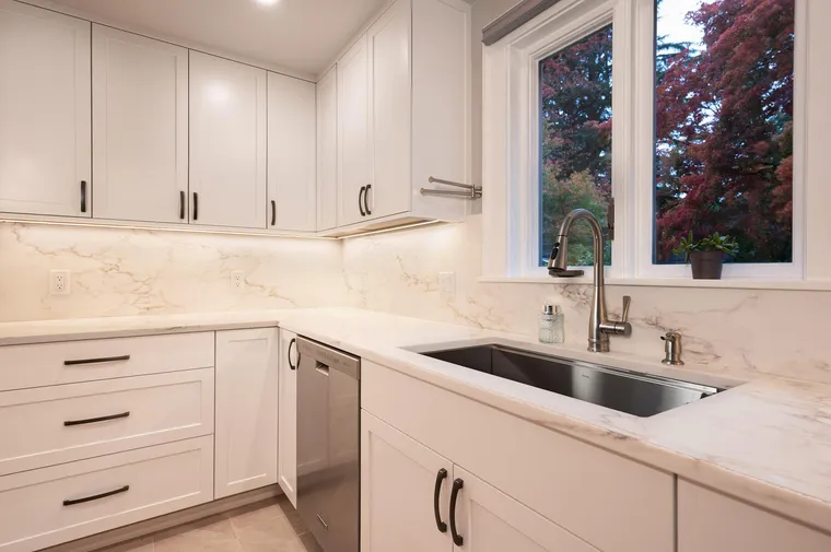 Undermount sink and marble-look counters beside a garden window