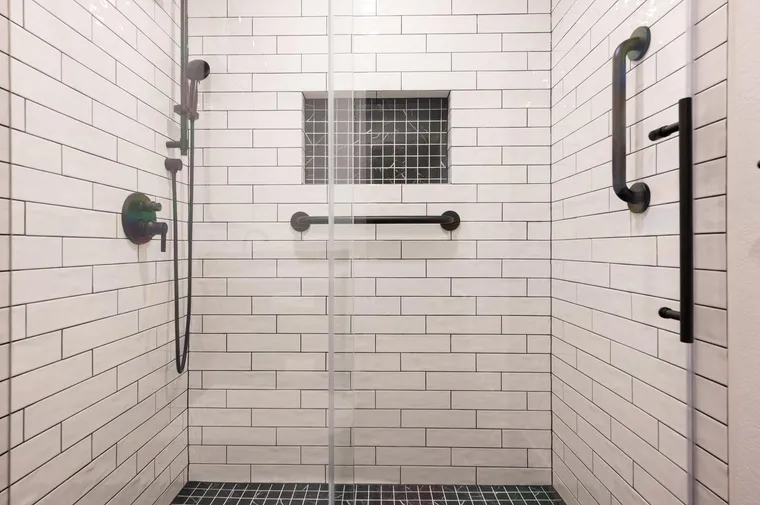Walk-in shower in white subway tile with black fixtures
