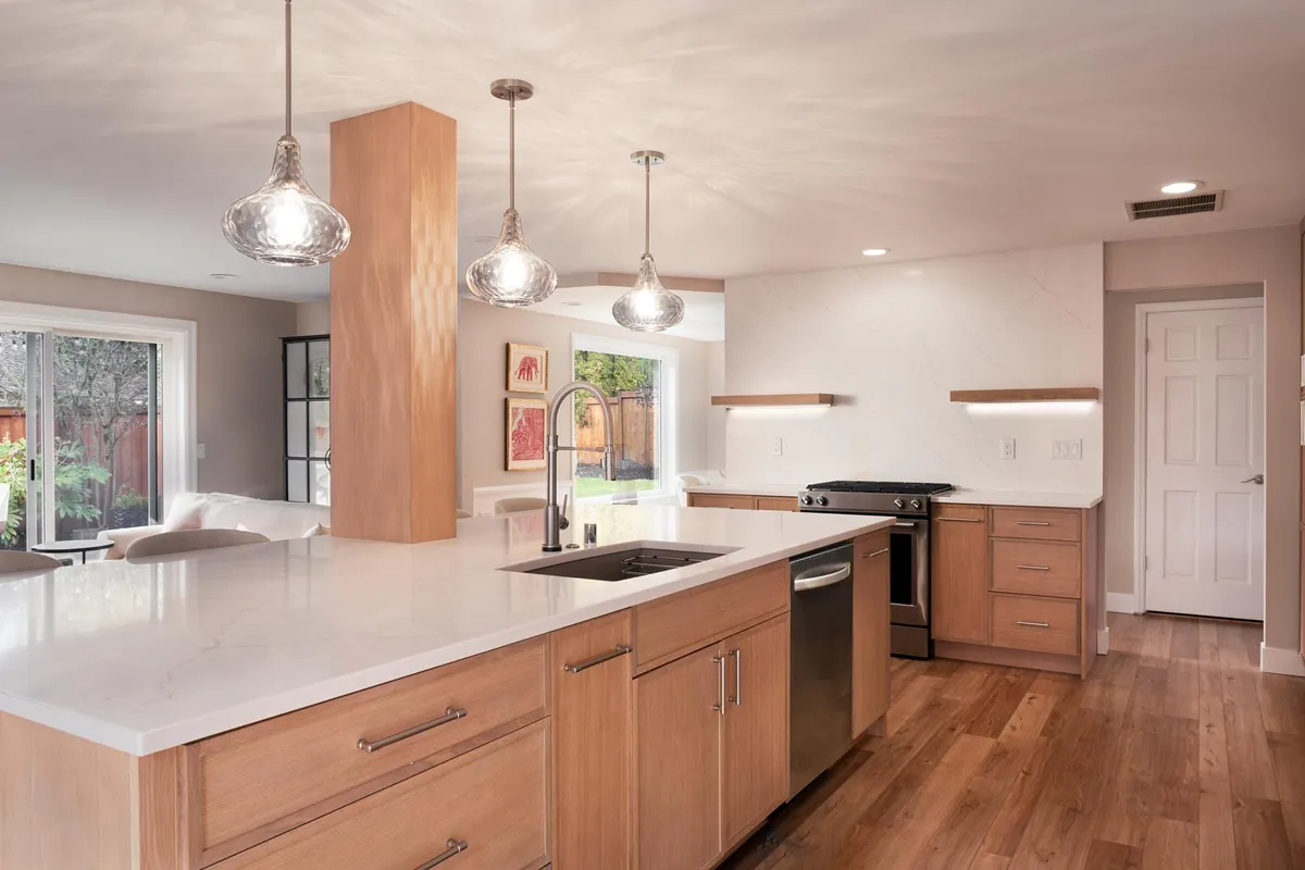 Open kitchen with glass pendants over a light oak island