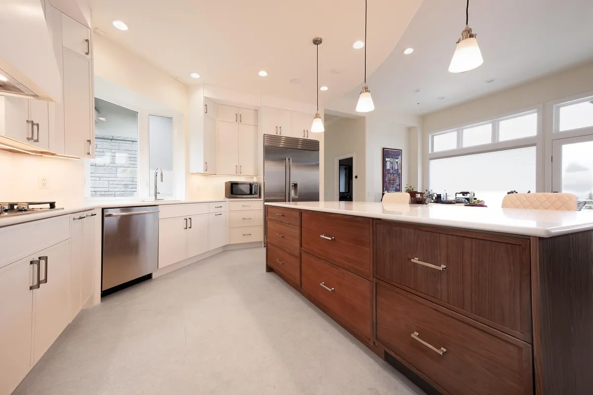 Long walnut island in a white kitchen