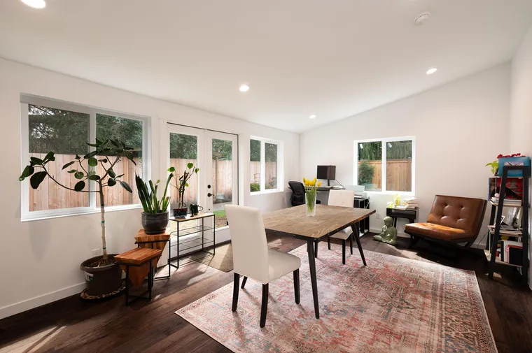 Sunny addition with dark wood floors and windows to the garden