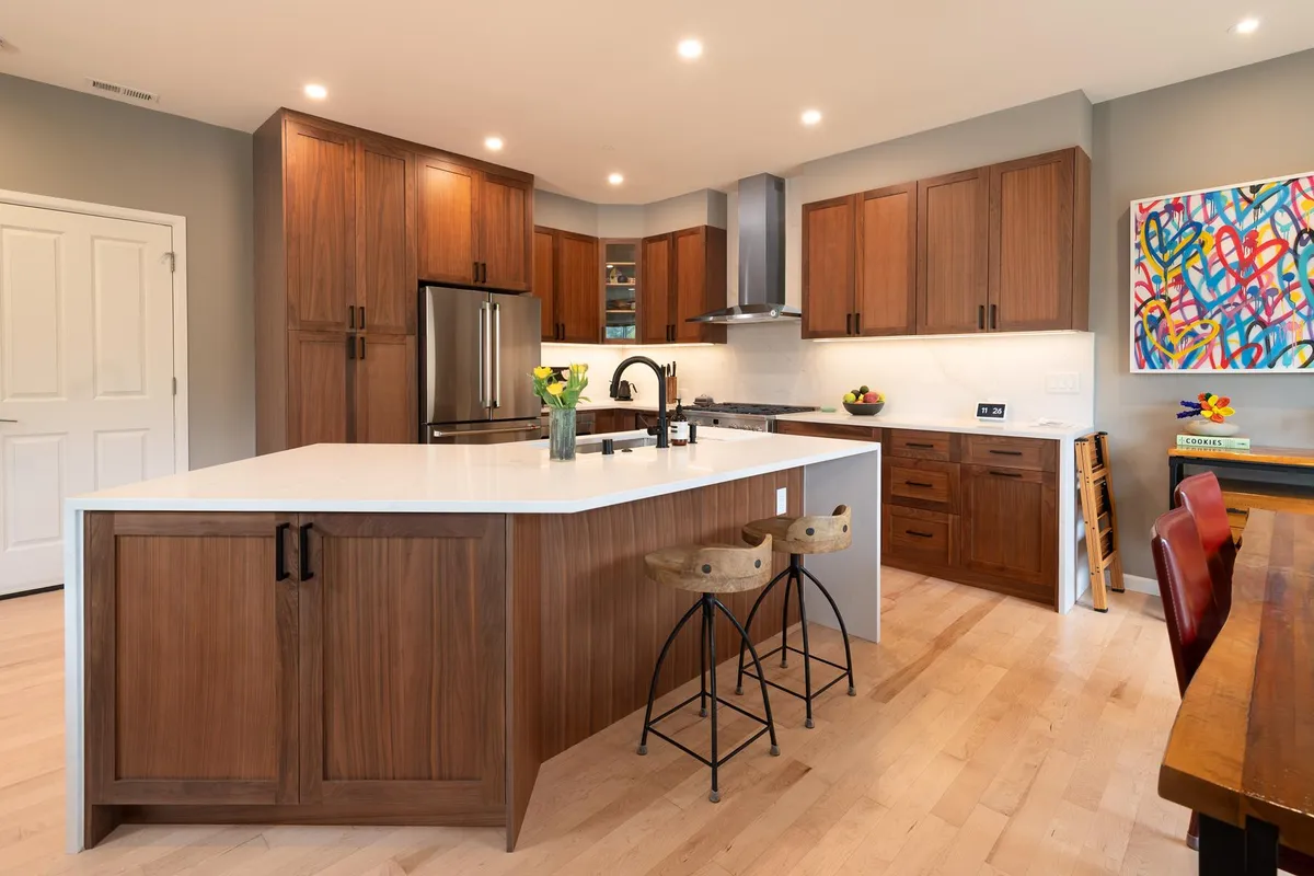 Walnut kitchen with a waterfall island and saddle stools in Kenmore