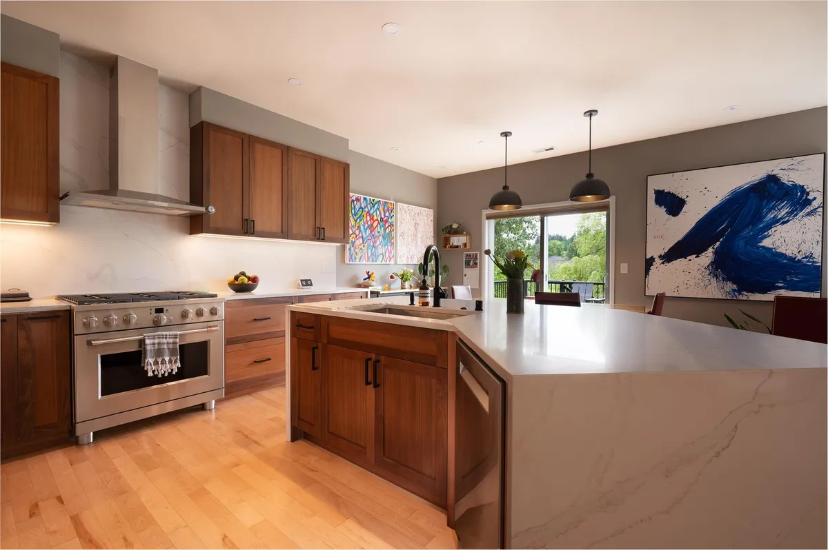Walnut kitchen with a range, a waterfall peninsula and pendant lights