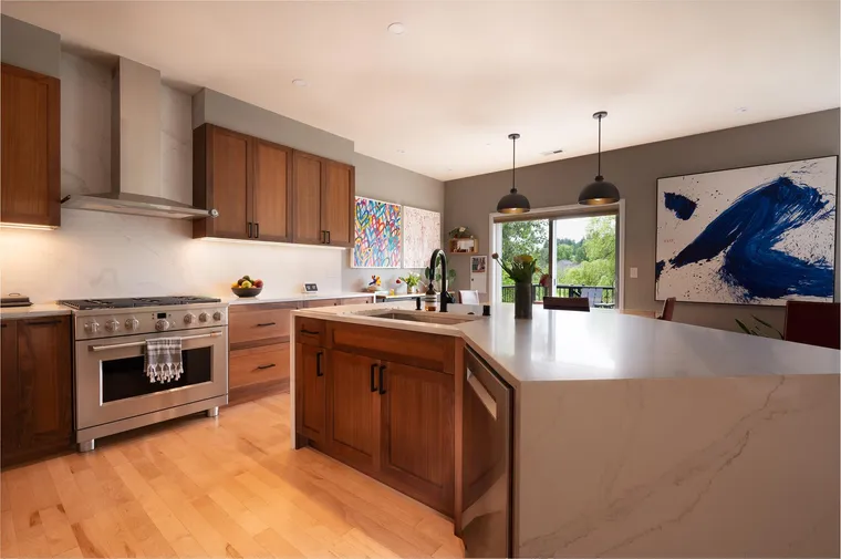 Walnut kitchen with a range, a waterfall peninsula and pendant lights