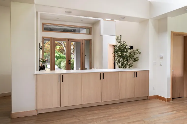White oak built-in cabinets below a pass-through to the garden
