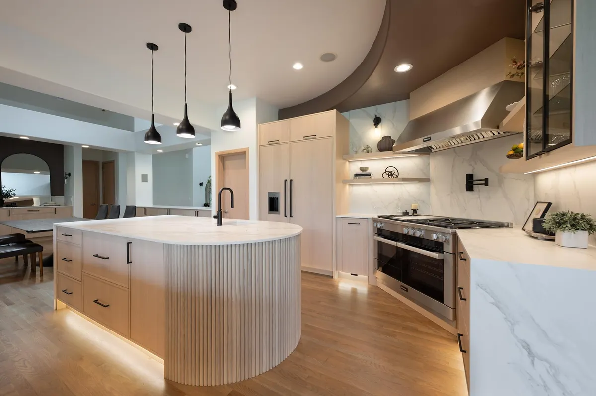 Curved, fluted white oak island under black pendant lights in Sammamish